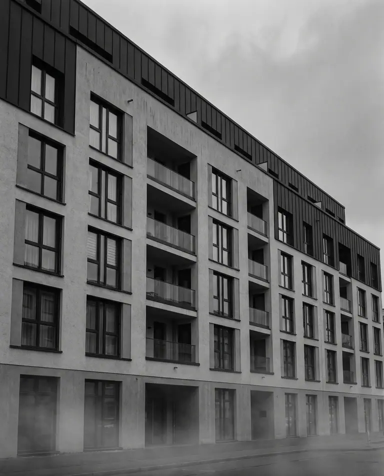 Wohn- und Geschäftshaus in Schwarzweiß, aufgenommen von der Straßenecke