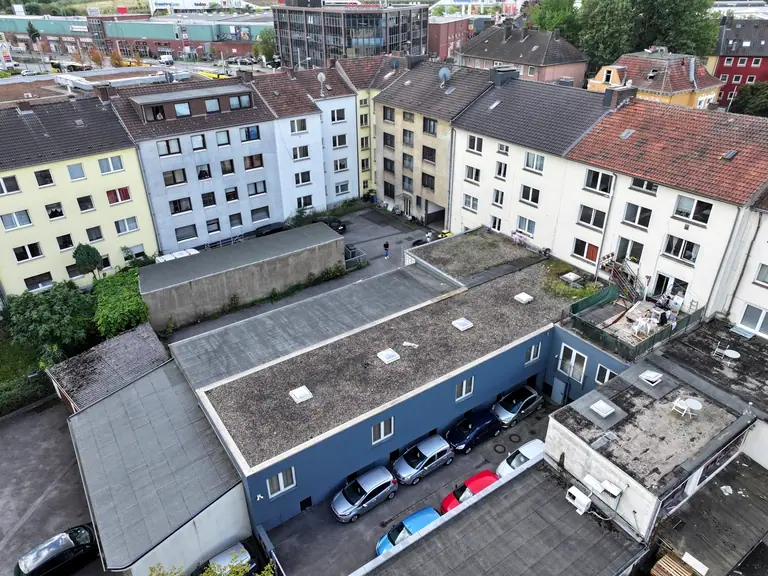 Luftaufnahme über Hof, Dachflächen und Garagen eines Wohn- und Geschäftshauses